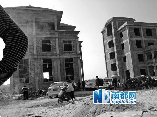 兩棟被舉報的違建樓下昨日一度聚集了超過百人，城管離開后逐漸散去。南都記者張志韜實習生宋超攝