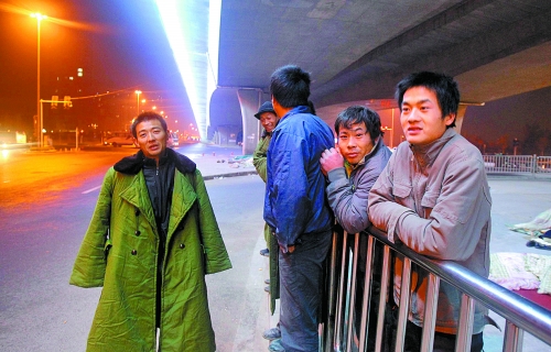 冬夜里，農民工在橋下等著干活兒。