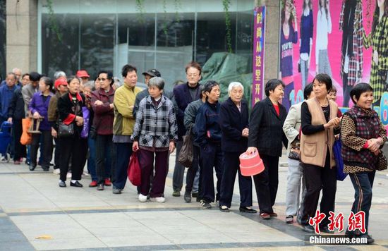 圖為10月28日，在江西九江市一家羊絨皮草服裝服飾博覽會(huì)現(xiàn)場，老人們正在頂著寒風(fēng)排隊(duì)等待領(lǐng)取10元代金劵。